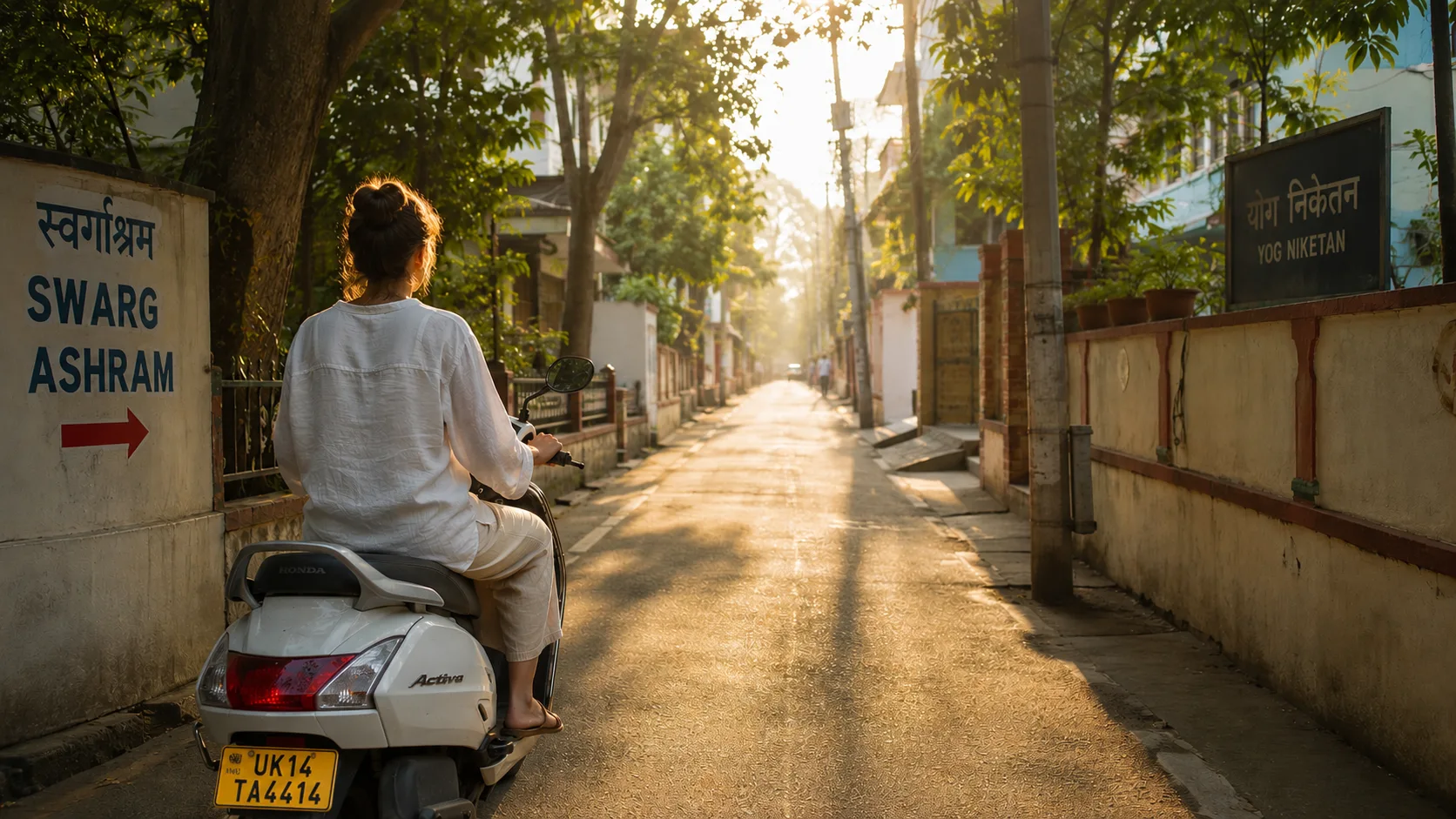 Woman riding a Honda Activa scooty down a quiet Swarg Ashram lane in Rishikesh at sunrise